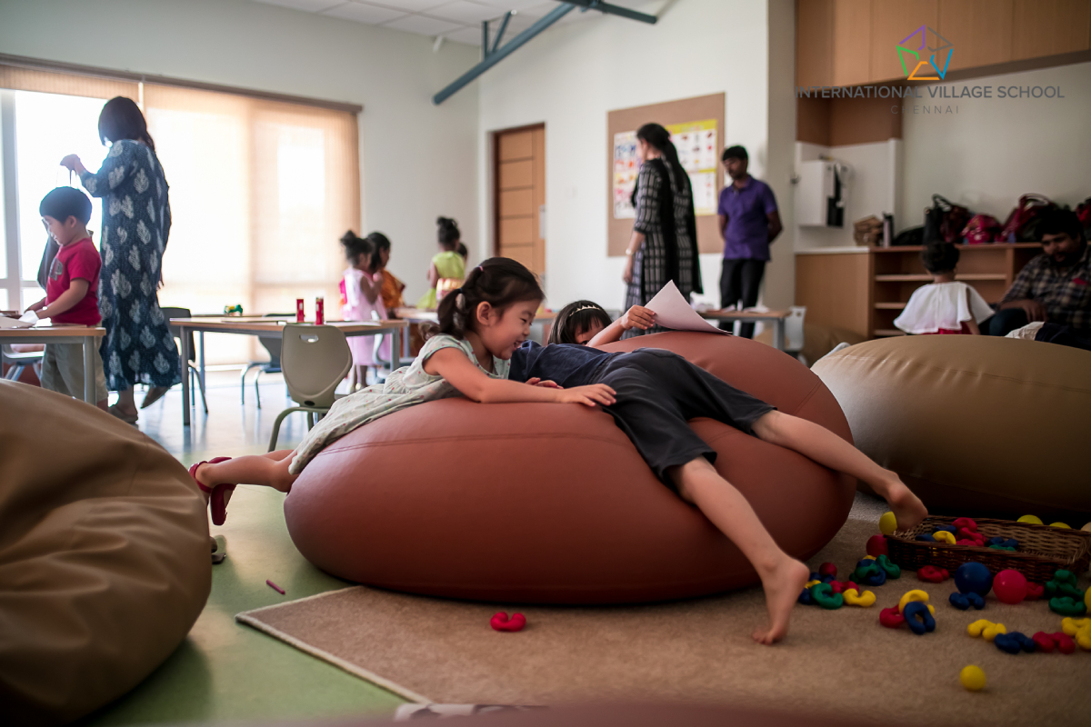 Small children playing inside a classroom.