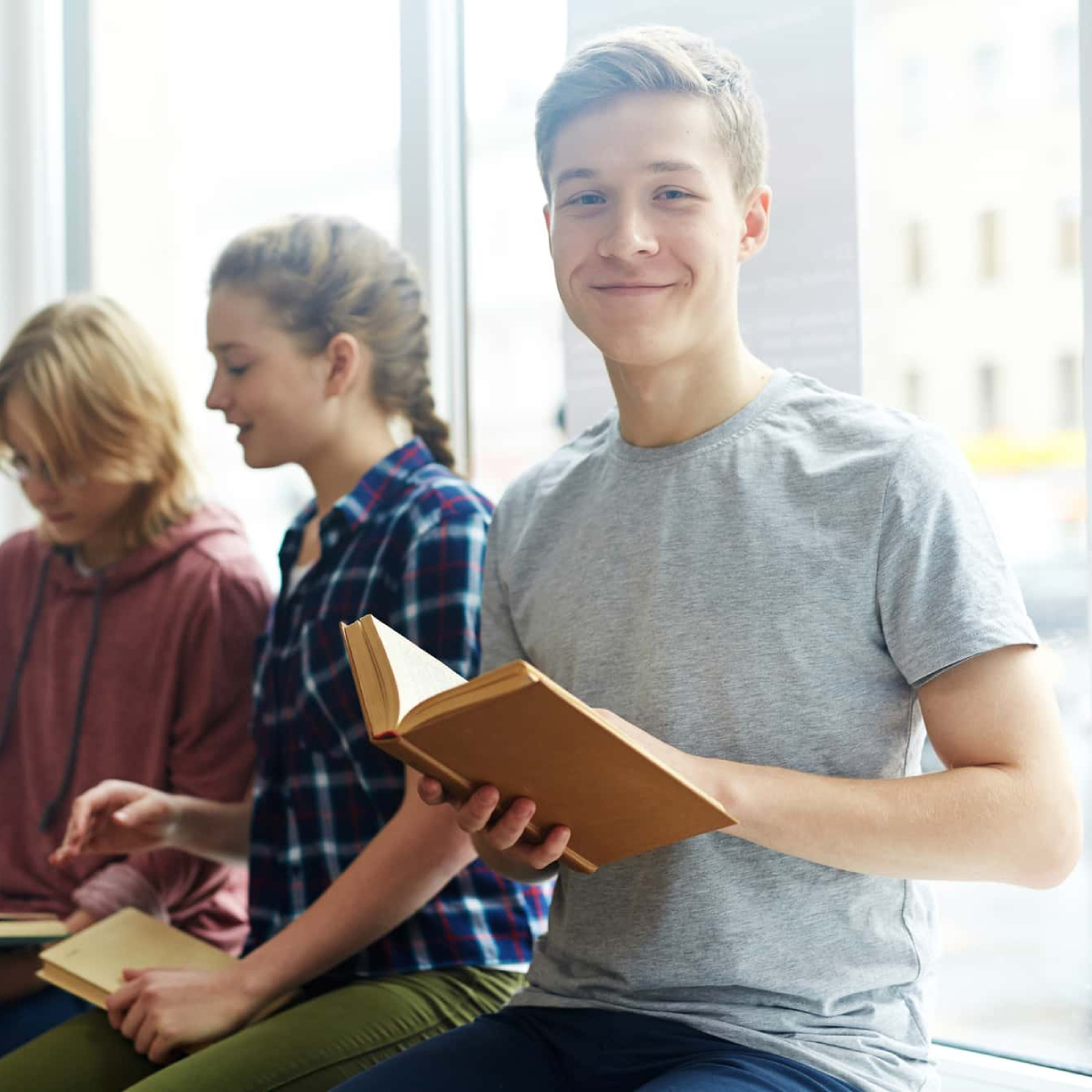 Middle Year School boy reading with his team poses for a click.