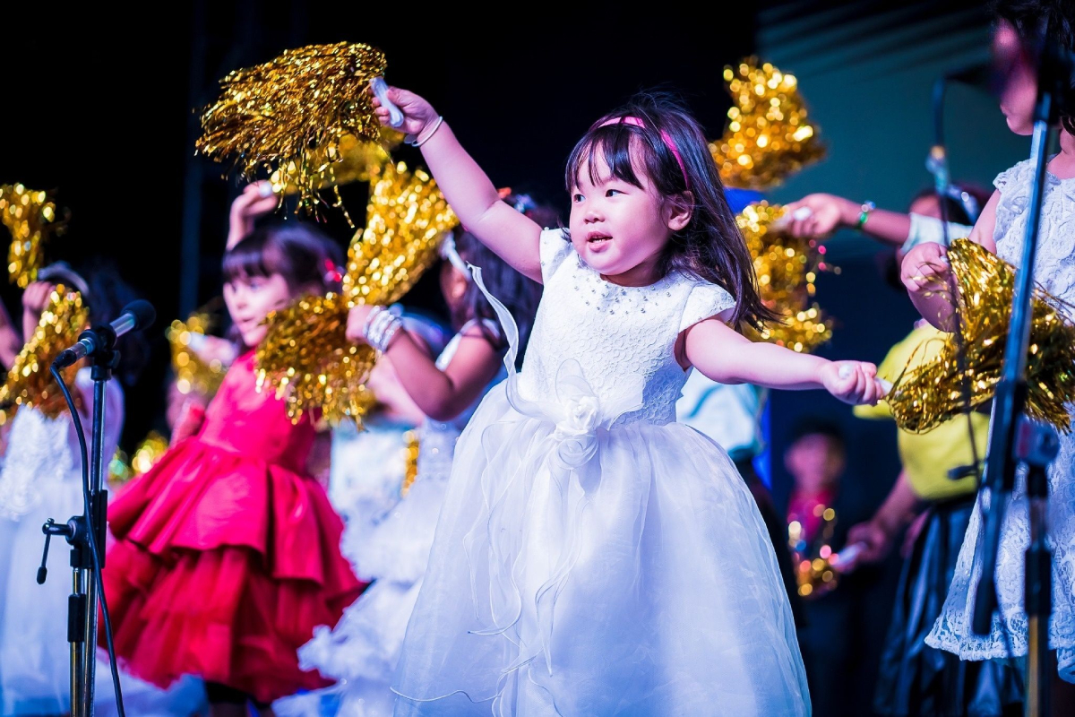 Tiny tots giving a dance performance with cheerleading pom poms.