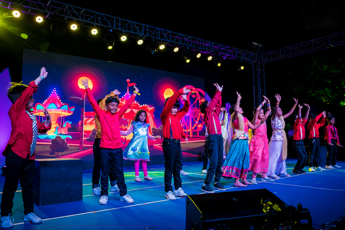 Young children performing on the stage at the International Village School.