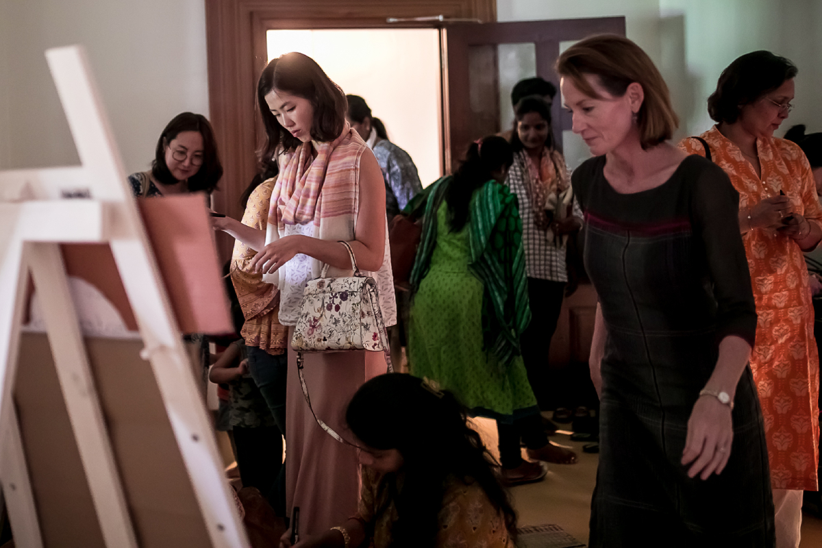 Guests admire the paintings.