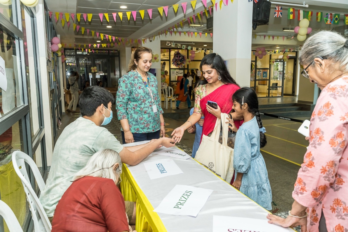Parents and children are collecting their prizes from the prize counter at the celebration.