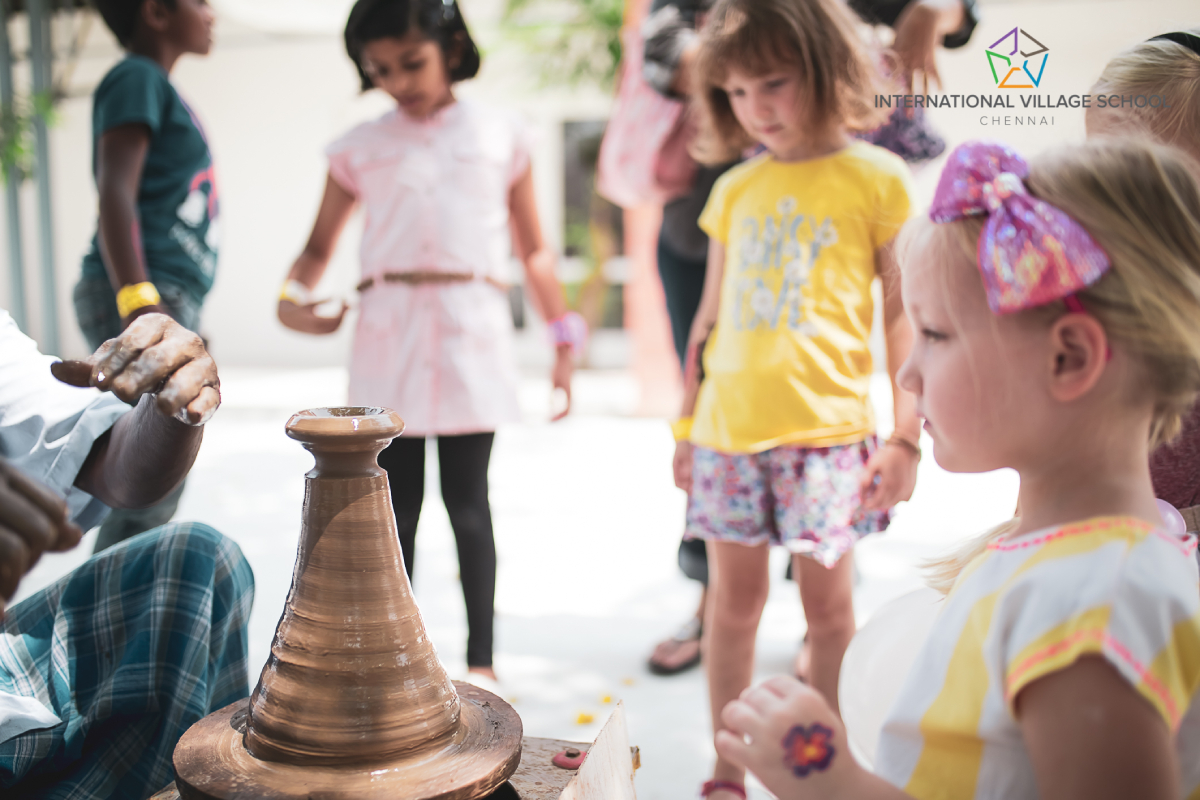 Small children actively participating in the pottery class.