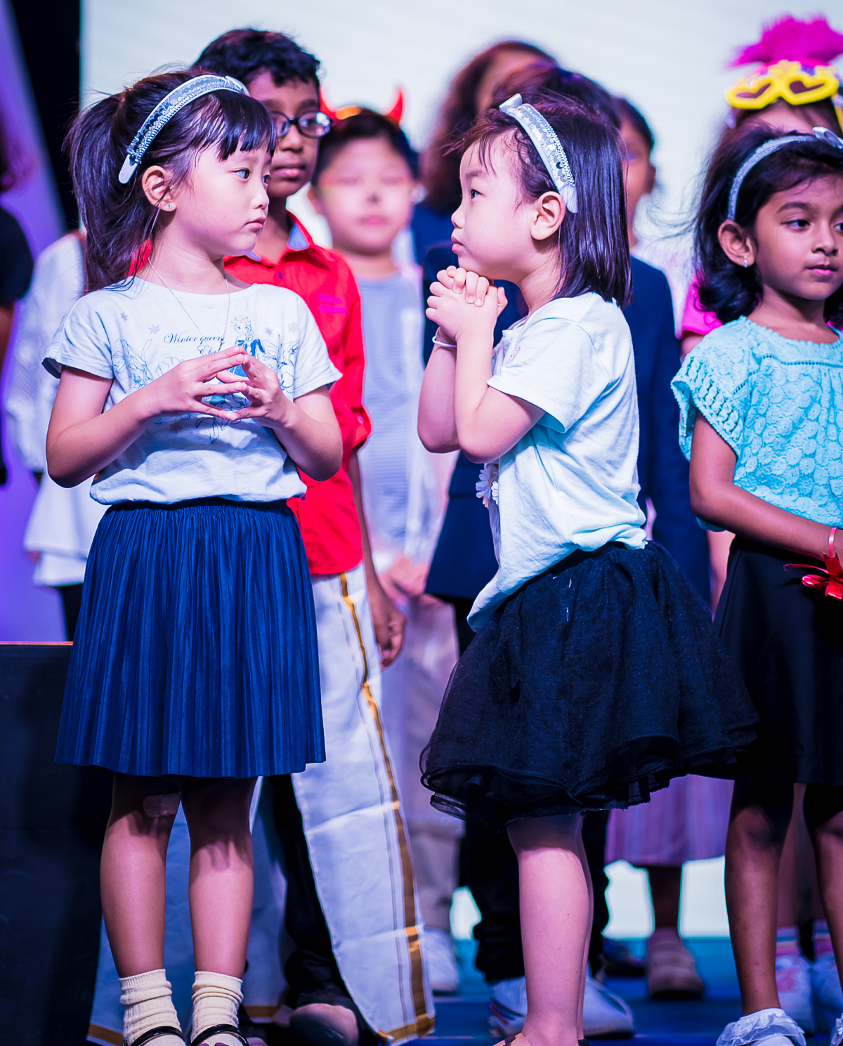 Small girls and boys on the stage at an event.