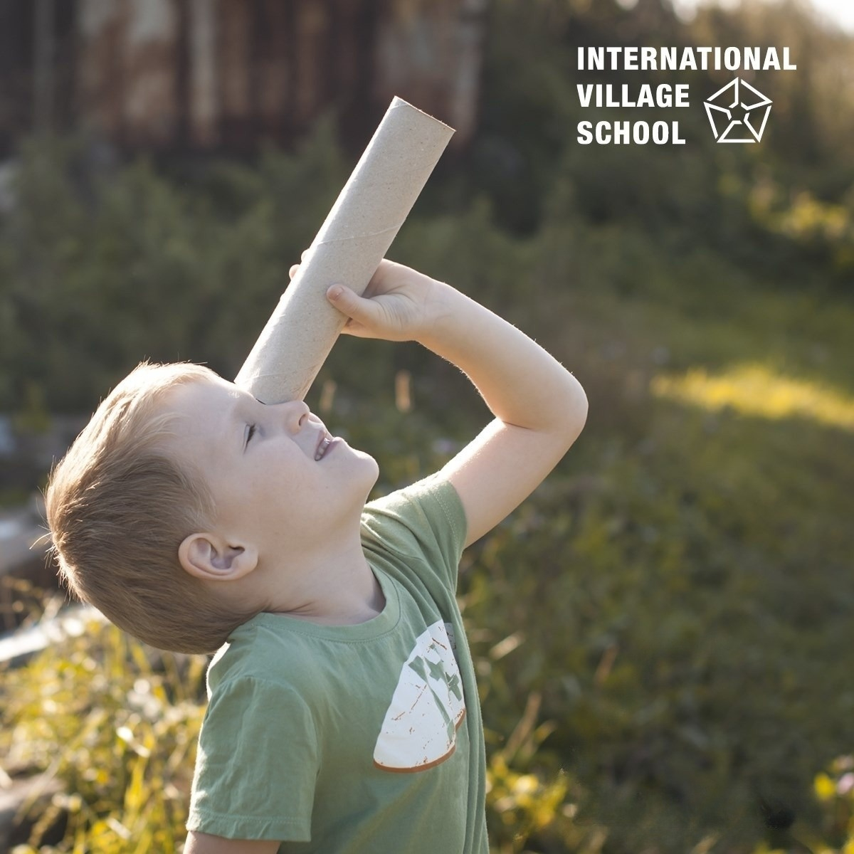 A small boy viewing the sky through a cardboard roll.